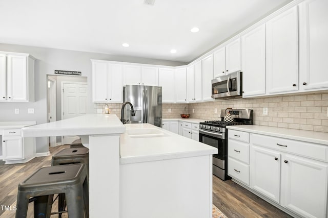 304 Forbes Rd, Wake Forest, NC 27587 - kitchen with appliances with stainless steel finishes, wood finished floors, a breakfast bar area, tasteful backsplash, and recessed lighting