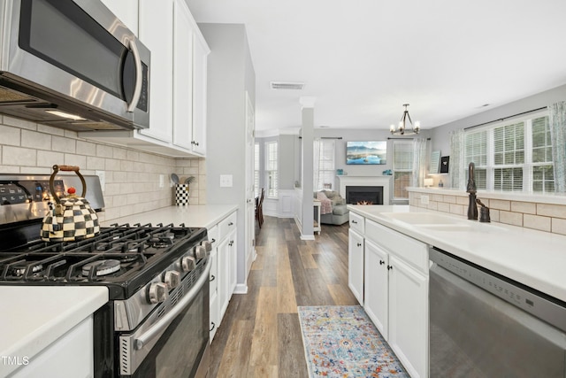 304 Forbes Rd, Wake Forest, NC 27587 - kitchen featuring appliances with stainless steel finishes, dark wood-type flooring, white cabinets, and healthy amount of natural light