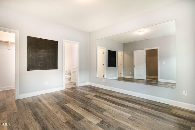 996 Tender Dr, Apex, NC 27502 - unfurnished bedroom featuring a walk in closet, wood finished floors, a closet, and ensuite bathroom