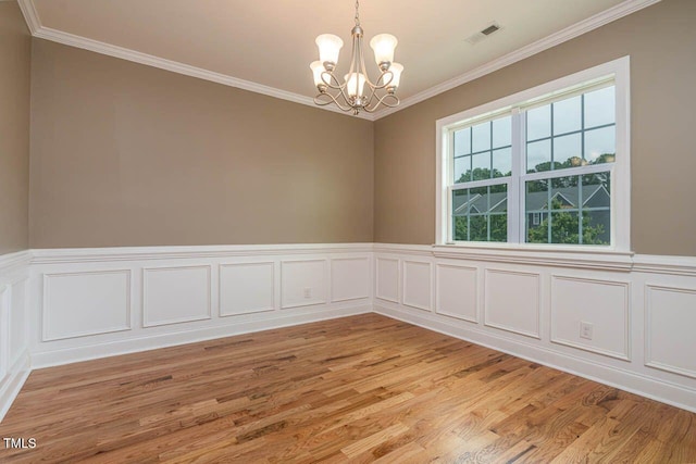 996 Tender Dr, Apex, NC 27502 - spare room with a chandelier, crown molding, light wood-style floors, wainscoting, and a decorative wall