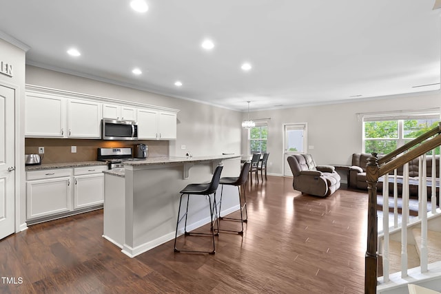 8005 Caithness St, Raleigh, NC 27616 - kitchen featuring appliances with stainless steel finishes, plenty of natural light, ornamental molding, light stone countertops, and recessed lighting