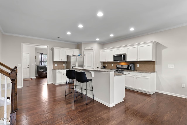 8005 Caithness St, Raleigh, NC 27616 - kitchen with appliances with stainless steel finishes, crown molding, dark wood-type flooring, a kitchen bar, and white cabinets