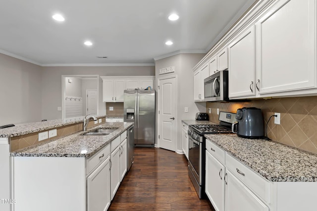 8005 Caithness St, Raleigh, NC 27616 - kitchen with stainless steel appliances, crown molding, white cabinetry, tasteful backsplash, and an island with sink