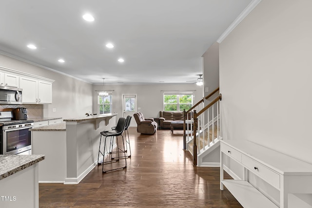 8005 Caithness St, Raleigh, NC 27616 - kitchen featuring stainless steel appliances, ornamental molding, recessed lighting, a kitchen bar, and white cabinets