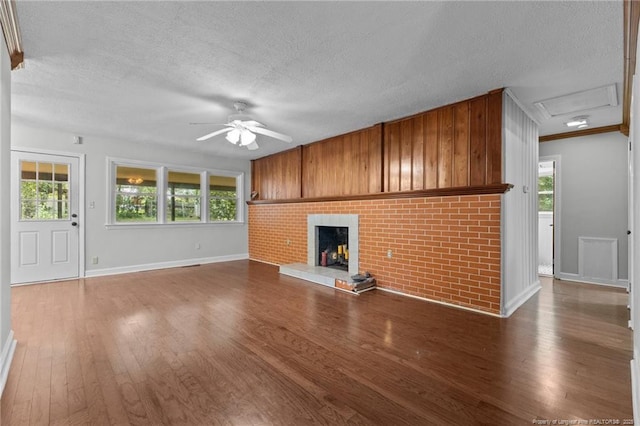 1905 Mcgougan Rd, Fayetteville, NC 28303 - unfurnished living room with a textured ceiling, a ceiling fan, wood finished floors, plenty of natural light, and a fireplace
