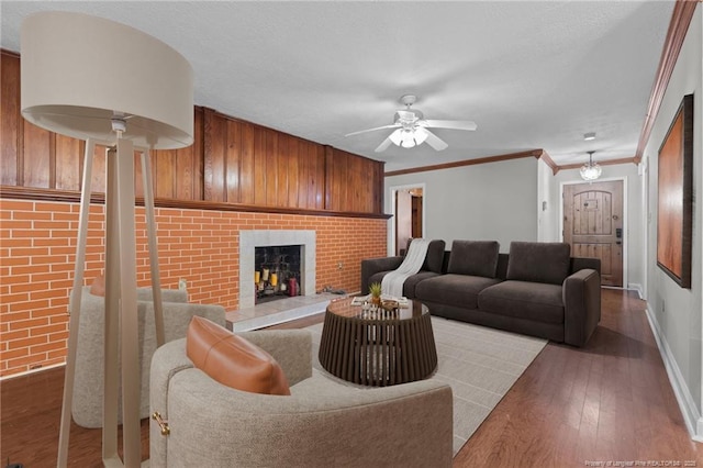 1905 Mcgougan Rd, Fayetteville, NC 28303 - living room featuring a brick fireplace, wood finished floors, ceiling fan, and ornamental molding