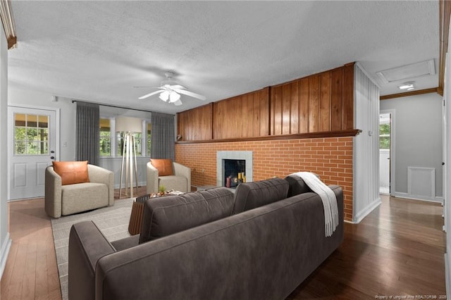1905 Mcgougan Rd, Fayetteville, NC 28303 - living area with dark wood-style floors, plenty of natural light, ceiling fan, a textured ceiling, and a brick fireplace