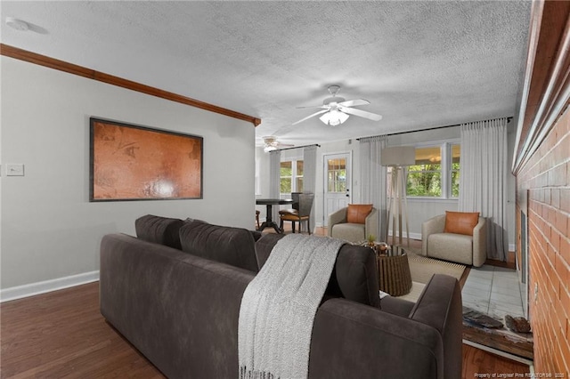 1905 Mcgougan Rd, Fayetteville, NC 28303 - living room with a ceiling fan, ornamental molding, a textured ceiling, a brick fireplace, and wood finished floors