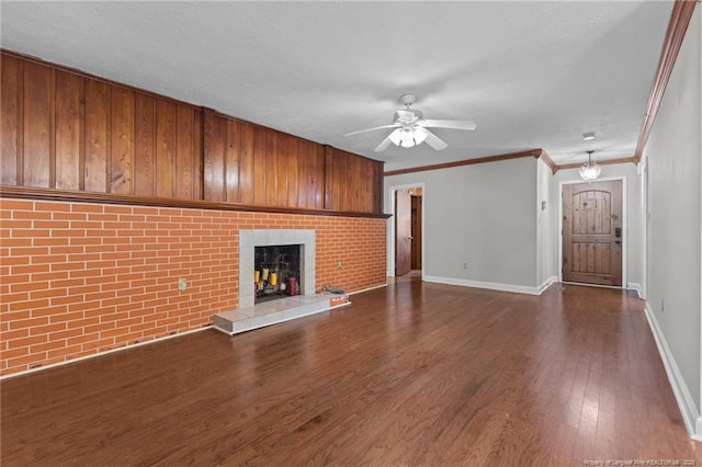 1905 Mcgougan Rd, Fayetteville, NC 28303 - unfurnished living room featuring ceiling fan, a fireplace with raised hearth, dark wood-style flooring, ornamental molding, and a textured ceiling