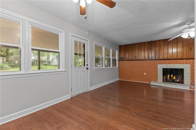1905 Mcgougan Rd, Fayetteville, NC 28303 - unfurnished living room featuring ceiling fan, wood finished floors, a fireplace, and a textured ceiling