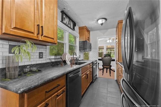 1905 Mcgougan Rd, Fayetteville, NC 28303 - kitchen with black appliances, brown cabinetry, plenty of natural light, backsplash, and a textured ceiling
