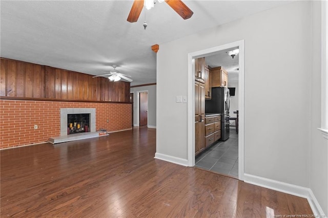 1905 Mcgougan Rd, Fayetteville, NC 28303 - unfurnished living room featuring ceiling fan, dark wood-style flooring, and a fireplace
