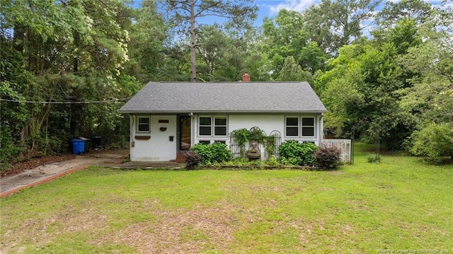 1905 Mcgougan Rd, Fayetteville, NC 28303 - view of front of house with a front lawn, a chimney, and view of wooded area