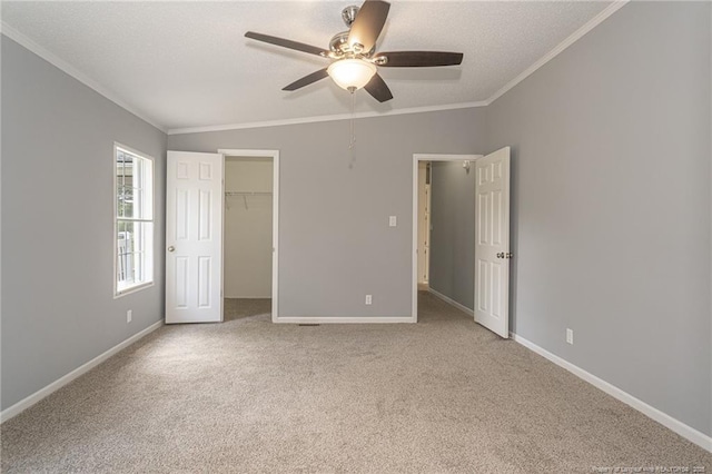 2990 Aberdeen Rd, Raeford, NC 28376 - unfurnished bedroom featuring ornamental molding, a textured ceiling, carpet flooring, ceiling fan, and a walk in closet