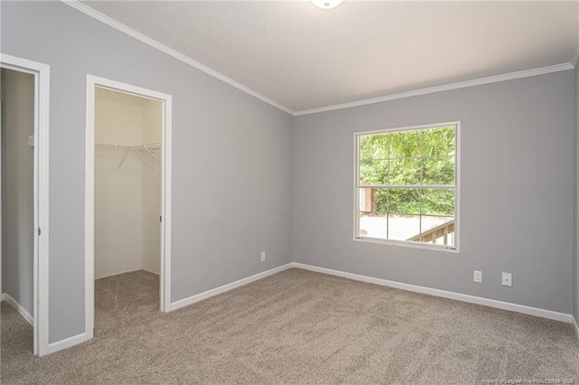 2990 Aberdeen Rd, Raeford, NC 28376 - unfurnished bedroom featuring carpet, a walk in closet, crown molding, vaulted ceiling, and a closet