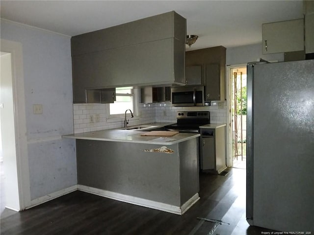 4627 Cheltenham Rd, Fayetteville, NC 28304 - kitchen featuring stainless steel appliances, backsplash, dark wood-style floors, a peninsula, and light countertops