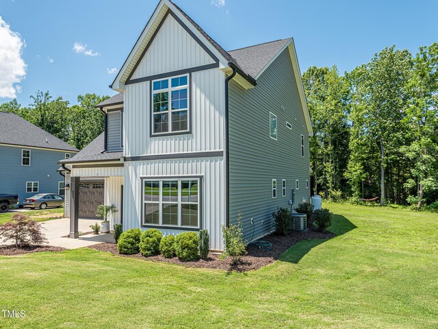 335 Glenn St, Franklinton, NC 27525 - view of front facade with roof with shingles, a front yard, driveway, and board and batten siding