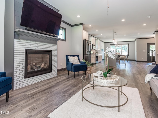 335 Glenn St, Franklinton, NC 27525 - living area with crown molding, recessed lighting, wood finished floors, and a fireplace