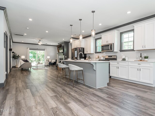 335 Glenn St, Franklinton, NC 27525 - kitchen featuring stainless steel microwave, open floor plan, freestanding refrigerator, a kitchen breakfast bar, and plenty of natural light