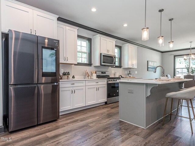 335 Glenn St, Franklinton, NC 27525 - kitchen with stainless steel appliances, ornamental molding, light countertops, white cabinetry, and a center island with sink