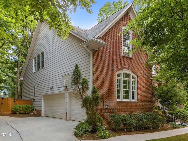 100 Redfoot Run Rd, Chapel Hill, NC 27516 - view of side of property with brick siding, a garage, concrete driveway, and a gate