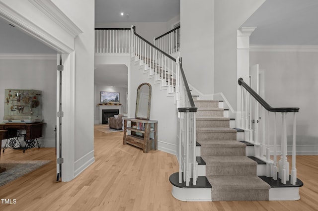 100 Redfoot Run Rd, Chapel Hill, NC 27516 - staircase featuring a fireplace, wood finished floors, a high ceiling, and ornamental molding