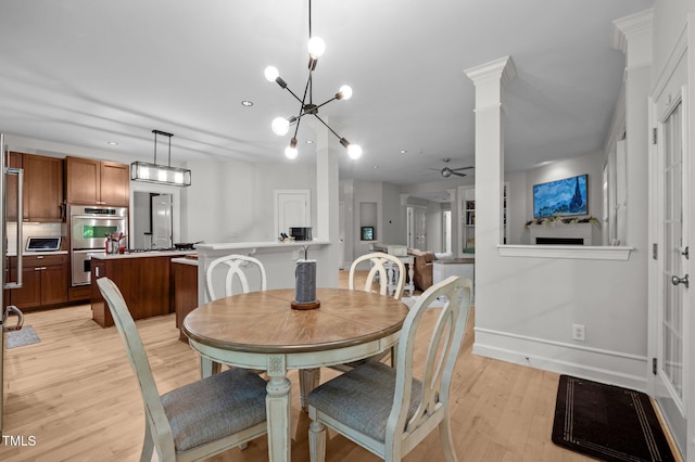 100 Redfoot Run Rd, Chapel Hill, NC 27516 - dining room featuring ceiling fan, light wood-style flooring, a chandelier, and ornate columns