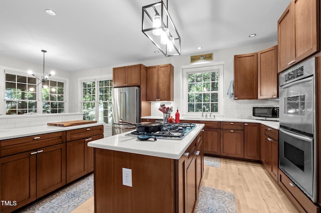 100 Redfoot Run Rd, Chapel Hill, NC 27516 - kitchen featuring appliances with stainless steel finishes, light wood finished floors, backsplash, brown cabinetry, and recessed lighting
