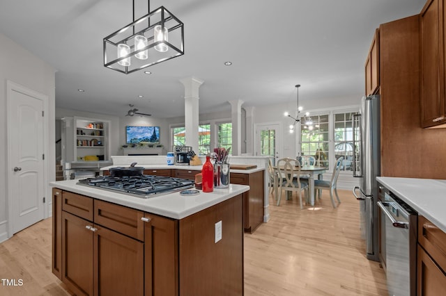 100 Redfoot Run Rd, Chapel Hill, NC 27516 - kitchen with stainless steel appliances, a center island, a chandelier, brown cabinetry, and light wood finished floors