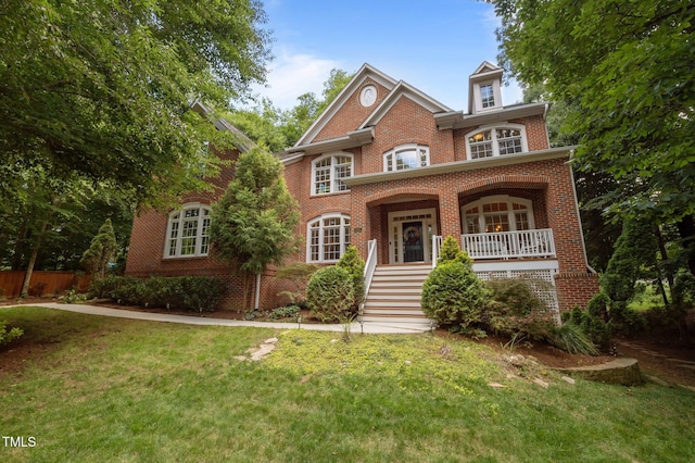 100 Redfoot Run Rd, Chapel Hill, NC 27516 - colonial inspired home featuring brick siding, a front lawn, covered porch, and stairway