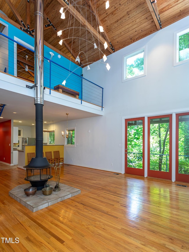 820 Runnymede Rd, Raleigh, NC 27607 - living room with a high ceiling, a wood stove, wood ceiling, wood finished floors, and rail lighting