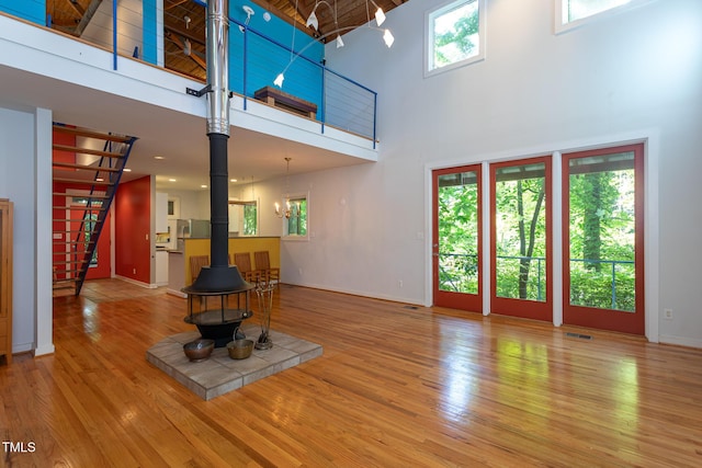 820 Runnymede Rd, Raleigh, NC 27607 - living area featuring a wood stove, a towering ceiling, and wood finished floors