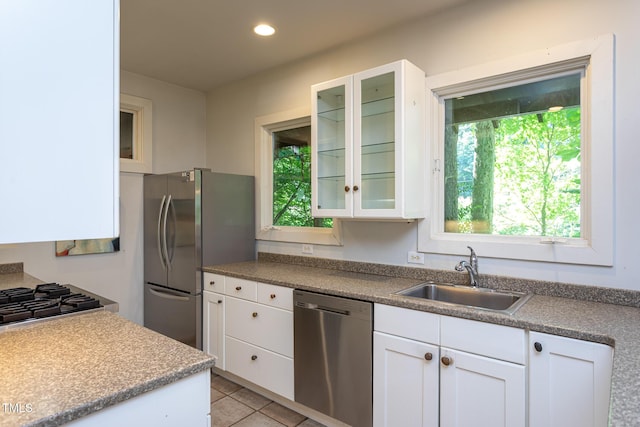 820 Runnymede Rd, Raleigh, NC 27607 - kitchen featuring appliances with stainless steel finishes, white cabinets, recessed lighting, glass insert cabinets, and light tile patterned floors