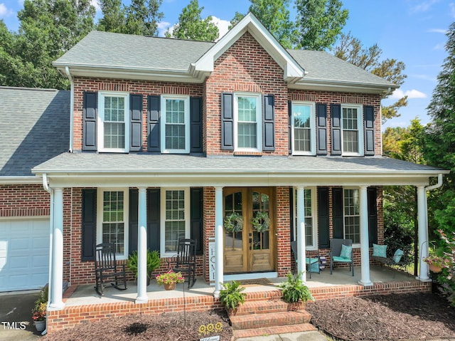 2925 Dargan Hills Dr, Wake Forest, NC 27587 - view of front facade with covered porch, brick siding, a shingled roof, and an attached garage