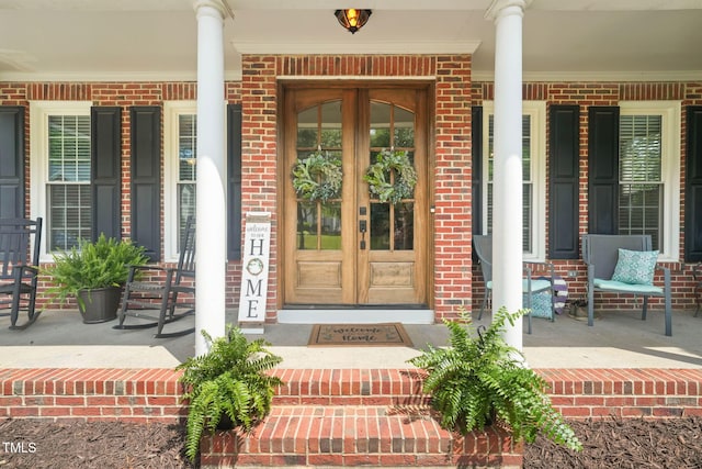 2925 Dargan Hills Dr, Wake Forest, NC 27587 - doorway to property featuring a porch, brick siding, and french doors