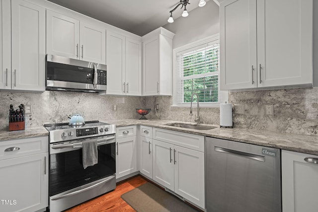 2925 Dargan Hills Dr, Wake Forest, NC 27587 - kitchen with stainless steel appliances, white cabinetry, wood finished floors, and decorative backsplash
