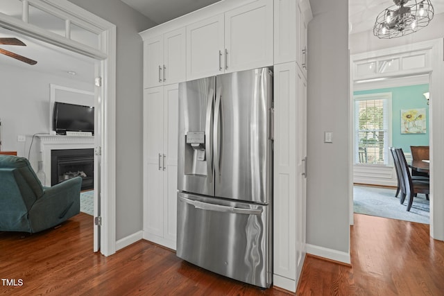 2925 Dargan Hills Dr, Wake Forest, NC 27587 - kitchen featuring stainless steel fridge with ice dispenser, dark wood-type flooring, white cabinetry, ceiling fan, and a fireplace