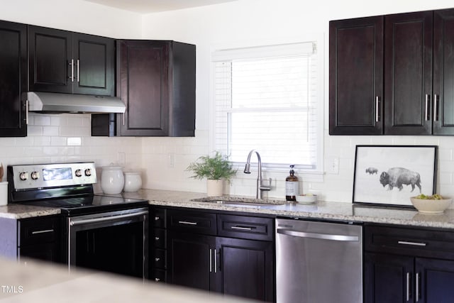 2801 E Shoreham St, Durham, NC 27707 - kitchen featuring appliances with stainless steel finishes, under cabinet range hood, backsplash, and light stone counters