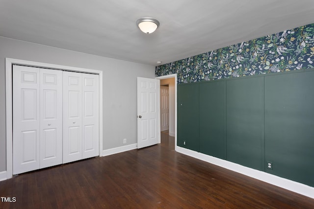 2801 E Shoreham St, Durham, NC 27707 - unfurnished bedroom with wood finished floors, wallpapered walls, and a closet