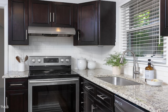 2801 E Shoreham St, Durham, NC 27707 - kitchen with under cabinet range hood, appliances with stainless steel finishes, tasteful backsplash, dark brown cabinetry, and light stone counters