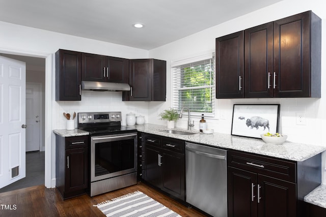 2801 E Shoreham St, Durham, NC 27707 - kitchen with stainless steel appliances, under cabinet range hood, backsplash, light stone counters, and dark wood finished floors