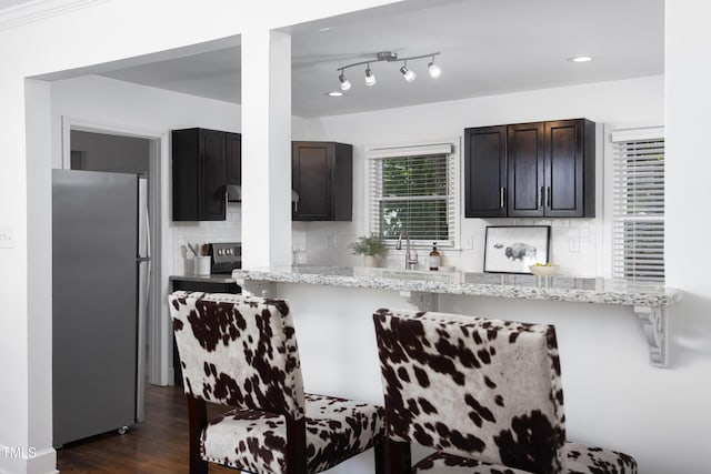 2801 E Shoreham St, Durham, NC 27707 - kitchen with freestanding refrigerator, backsplash, a breakfast bar, light stone counters, and recessed lighting