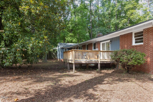 2801 E Shoreham St, Durham, NC 27707 - back of property with a wooden deck, a chimney, and brick siding