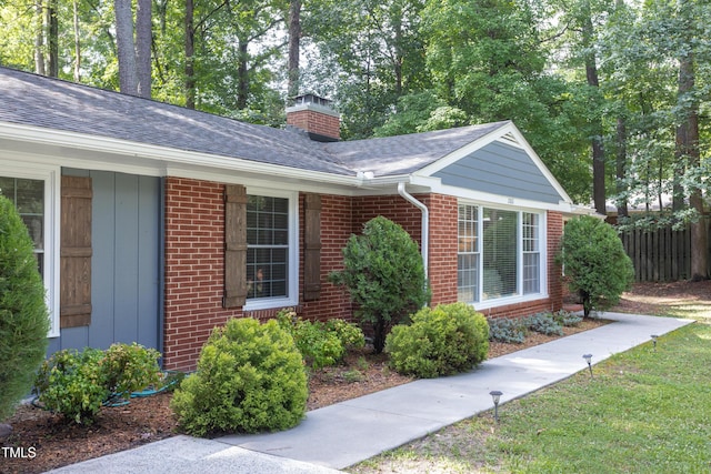2801 E Shoreham St, Durham, NC 27707 - view of property exterior with brick siding, a chimney, and a shingled roof