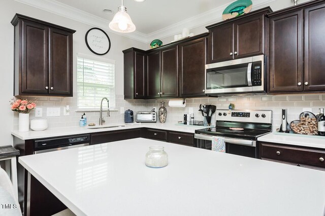 514 Alamanni Ct, Graham, NC 27253 - kitchen with stainless steel appliances, light countertops, backsplash, dark brown cabinetry, and crown molding