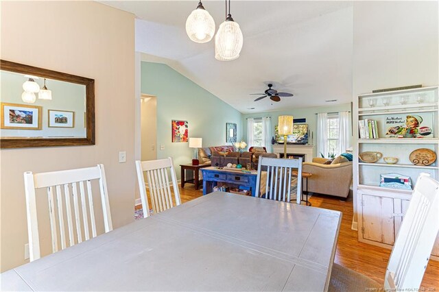 2 Beryl Cir, Pinehurst, NC 28374 - dining area featuring lofted ceiling, ceiling fan, wood finished floors, and a warm lit fireplace