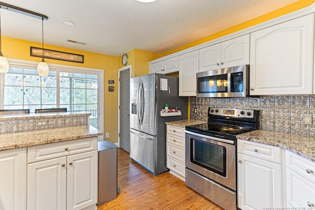 2 Beryl Cir, Pinehurst, NC 28374 - kitchen featuring stainless steel appliances, light wood finished floors, and white cabinetry