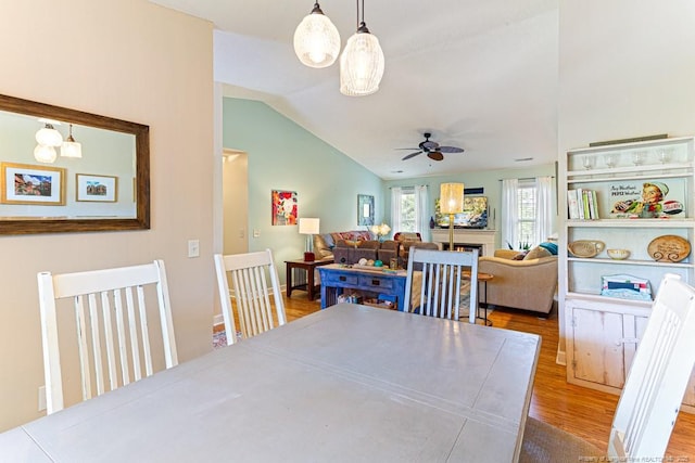 2 Beryl Cir, Pinehurst, NC 28374 - dining space featuring lofted ceiling, wood finished floors, ceiling fan, and a lit fireplace
