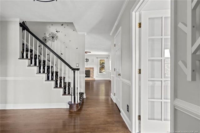4304 Ferncreek Dr, Fayetteville, NC 28314 - entryway featuring wood finished floors, stairway, a stone fireplace, crown molding, and a textured ceiling