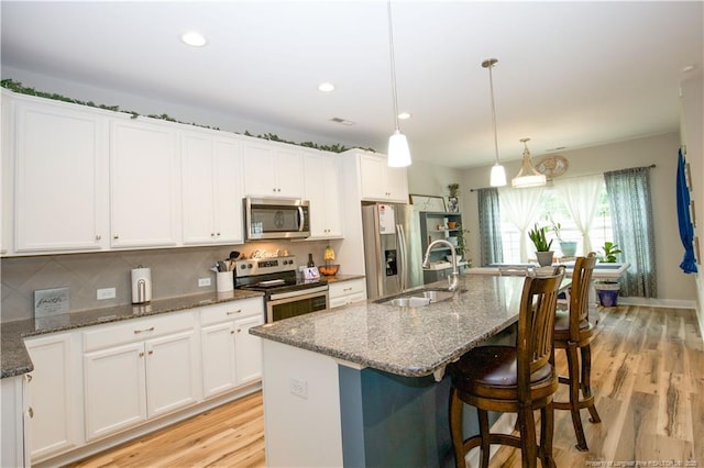 435 Lancaster Dr, Vass, NC 28394 - kitchen with appliances with stainless steel finishes, white cabinetry, a center island with sink, light wood finished floors, and recessed lighting